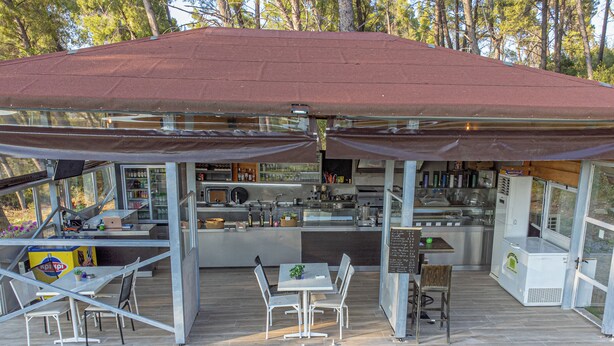A modern outdoor dining area with a covered patio, a bar, and a kitchen. - Medusa Rooms (Kassandra)