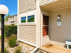 A single-story building with a front door, a small porch, and a welcome sign. - Riverfront Retreat! Walk to Downtown/Near Beaches! (South Haven)