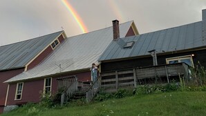 A rural setting with a house featuring a sloped roof and a chimney, surrounded by grass and a wooden fence. - Journey/Retreat ready! Private swimming hole, just 2hrs from Boston (Corinth)