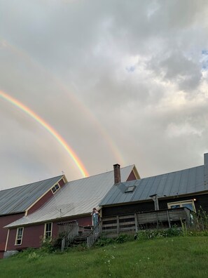 A rural setting with a house featuring a sloped roof and a chimney, surrounded by grass and a wooden fence. - Journey/Retreat ready! Private swimming hole, just 2hrs from Boston (Corinth)