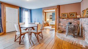 A dining area with a wooden table and chairs, a kitchen with a brick stove, and a living room with a sofa and a lamp. - Journey/Retreat ready! Private swimming hole, just 2hrs from Boston (Corinth)
