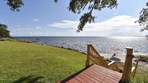 A wooden deck leading to a beach with a clear view of the ocean. - Eastpoint on the  Bay - private Beach, pool, sunsets (Eastpoint)