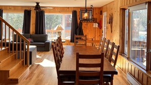 A wooden interior with a dining table, chairs, and hanging light fixtures. - BASE CAMP LA CONCEPTION (La Conception)