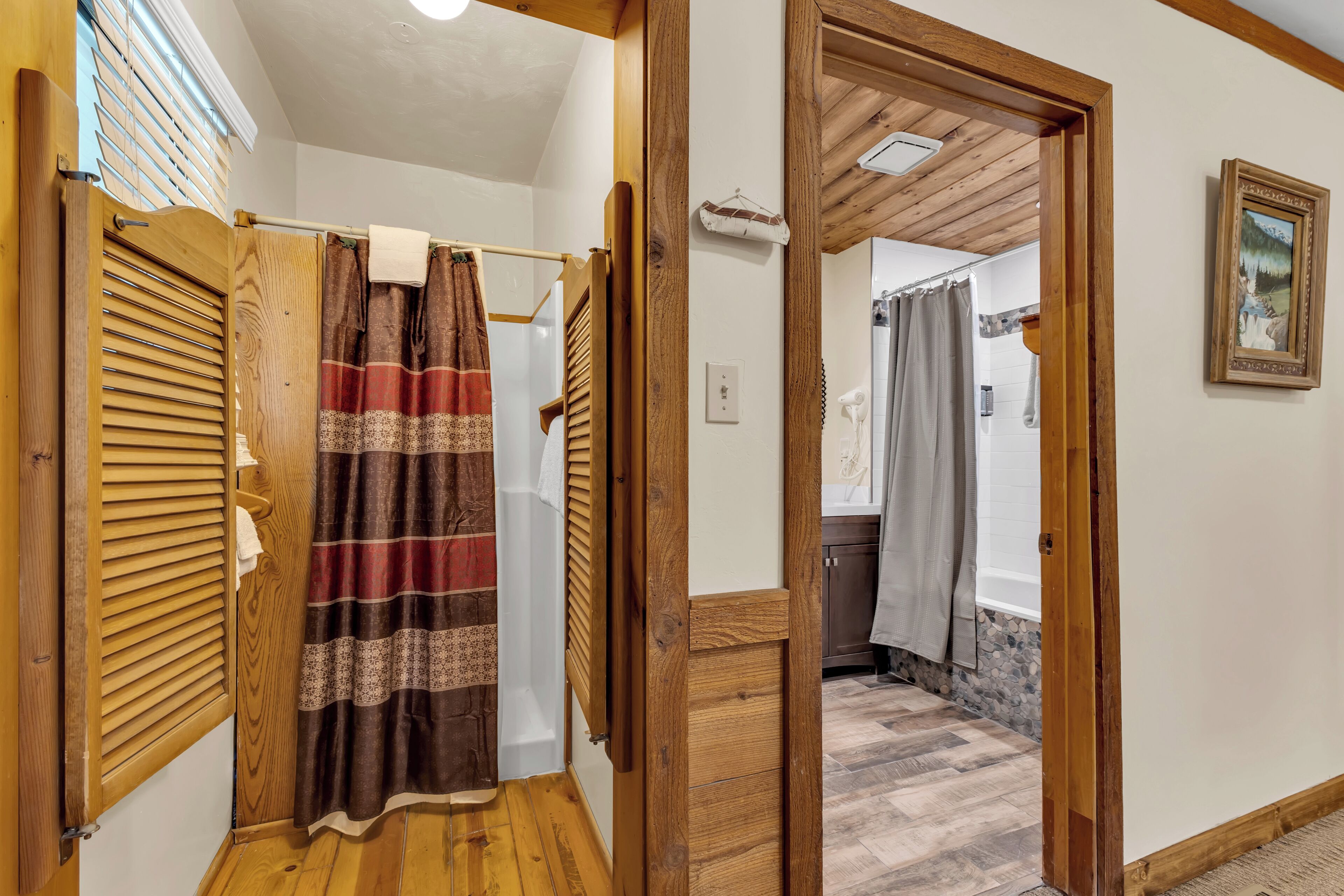 Una porta in legno che dà su un bagno con tenda doccia e un asciugamano appeso.