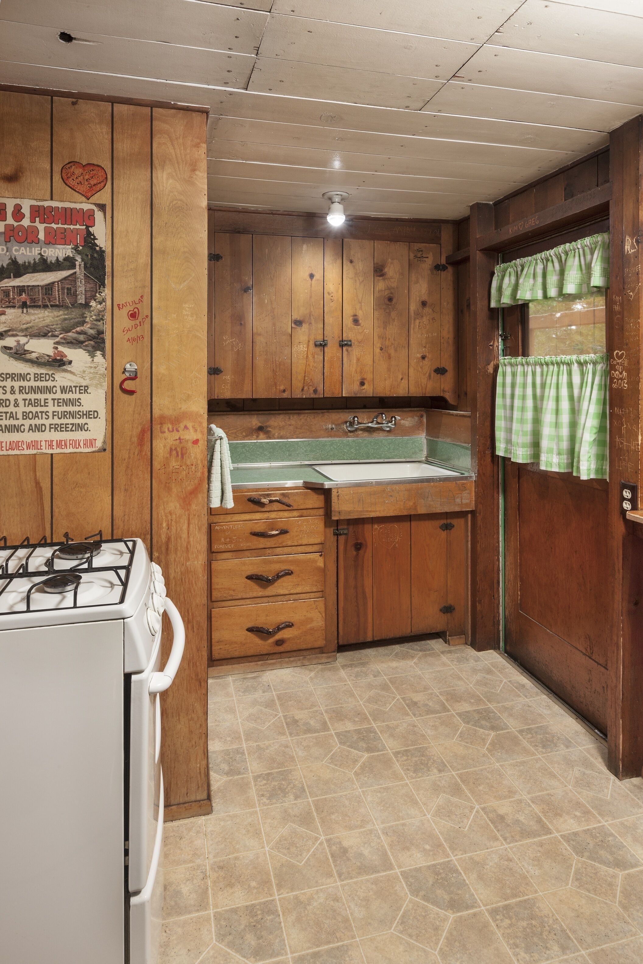 A compact kitchen with wooden cabinets, a gas stove, and a sink.