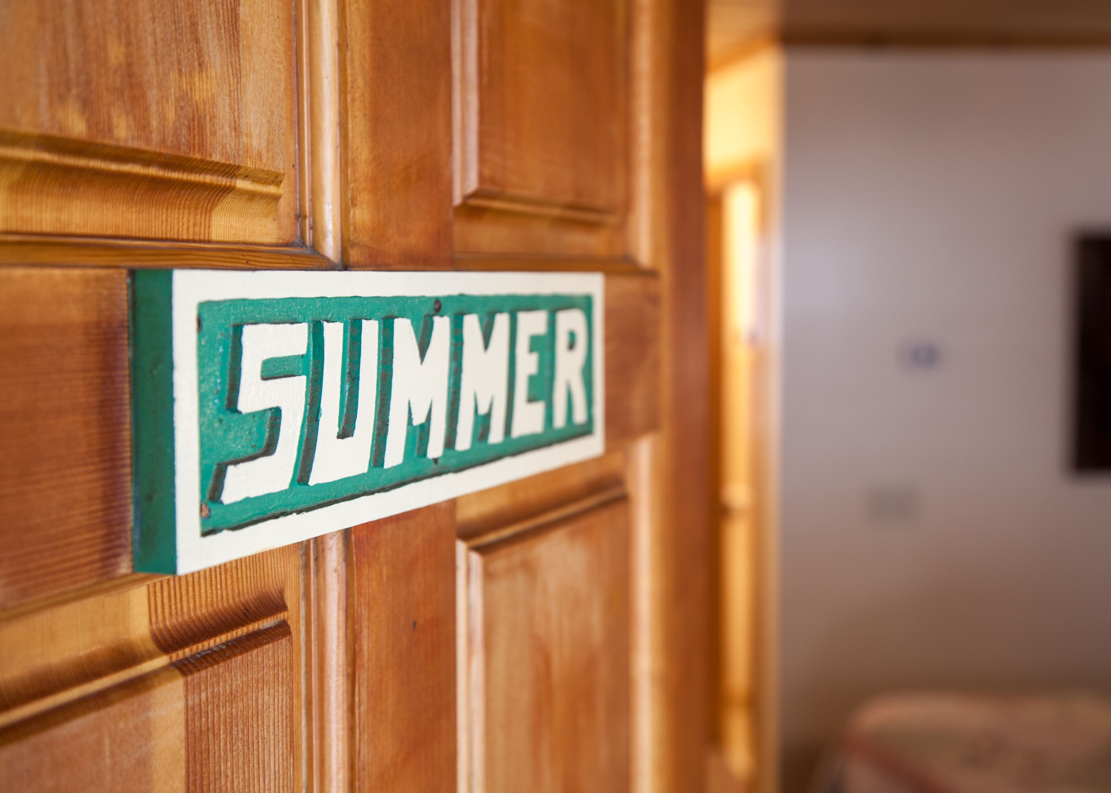 A wooden door with a sign that reads "SUMMER".