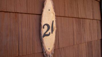 A wooden number plaque with the number 21 on a wooden wall.