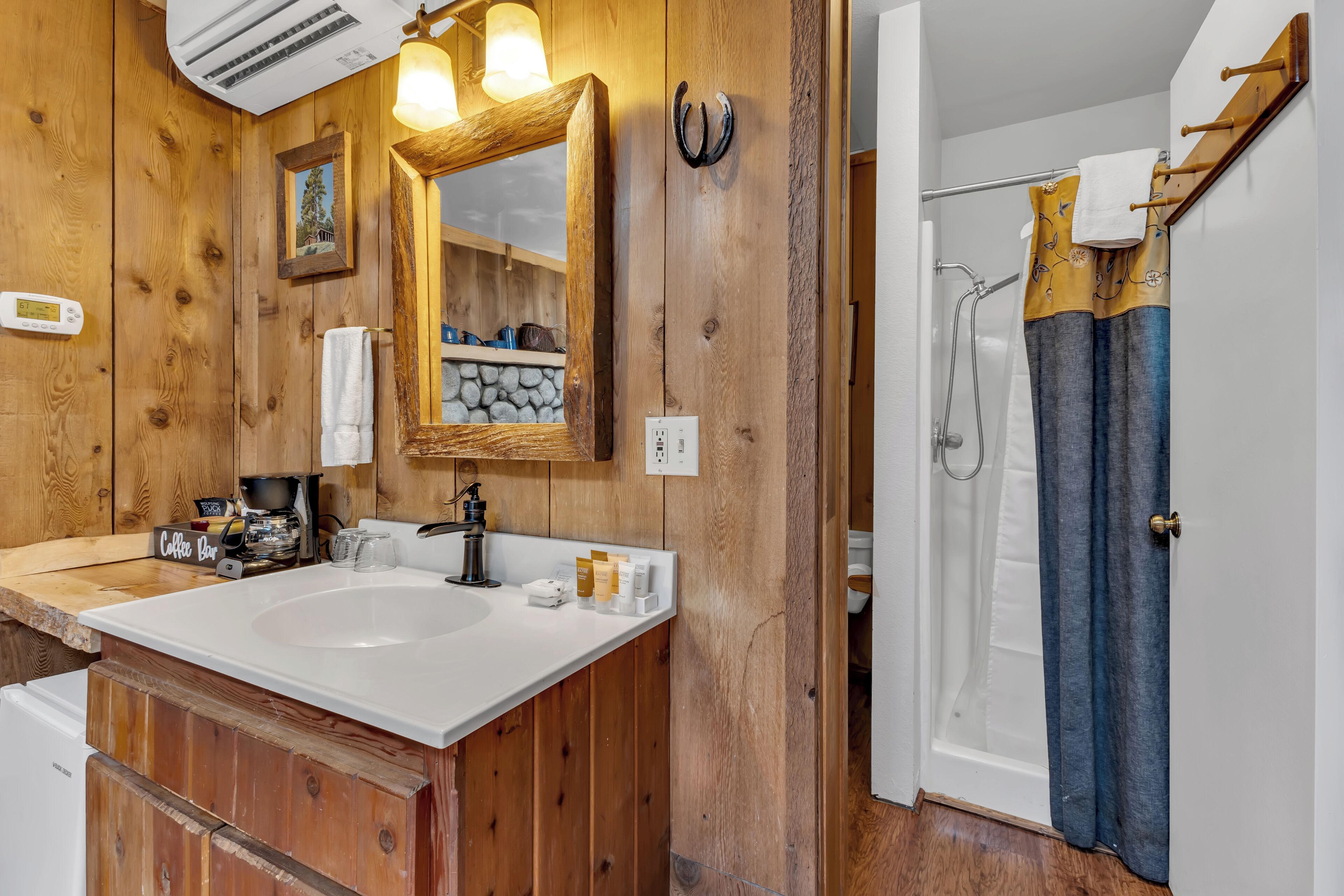 Une salle de bain en bois avec un double vasque, un miroir et un espace douche.