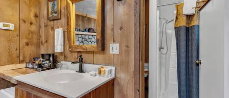 Une salle de bain en bois avec un double vasque, un miroir et un espace douche.