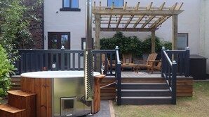 A hot tub with wooden steps and a pergola in a backyard. - Canal side cottage with hot tub, sky tv and log fire (Lathom)