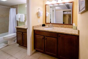 A bathroom with a sink, mirror, and shower. - Sandcastle Court #275 -Kitchen (Nassau County)