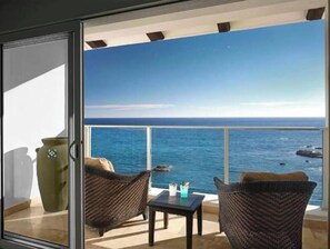 Enjoy the ocean view from this balcony with a comfortable seating area.
