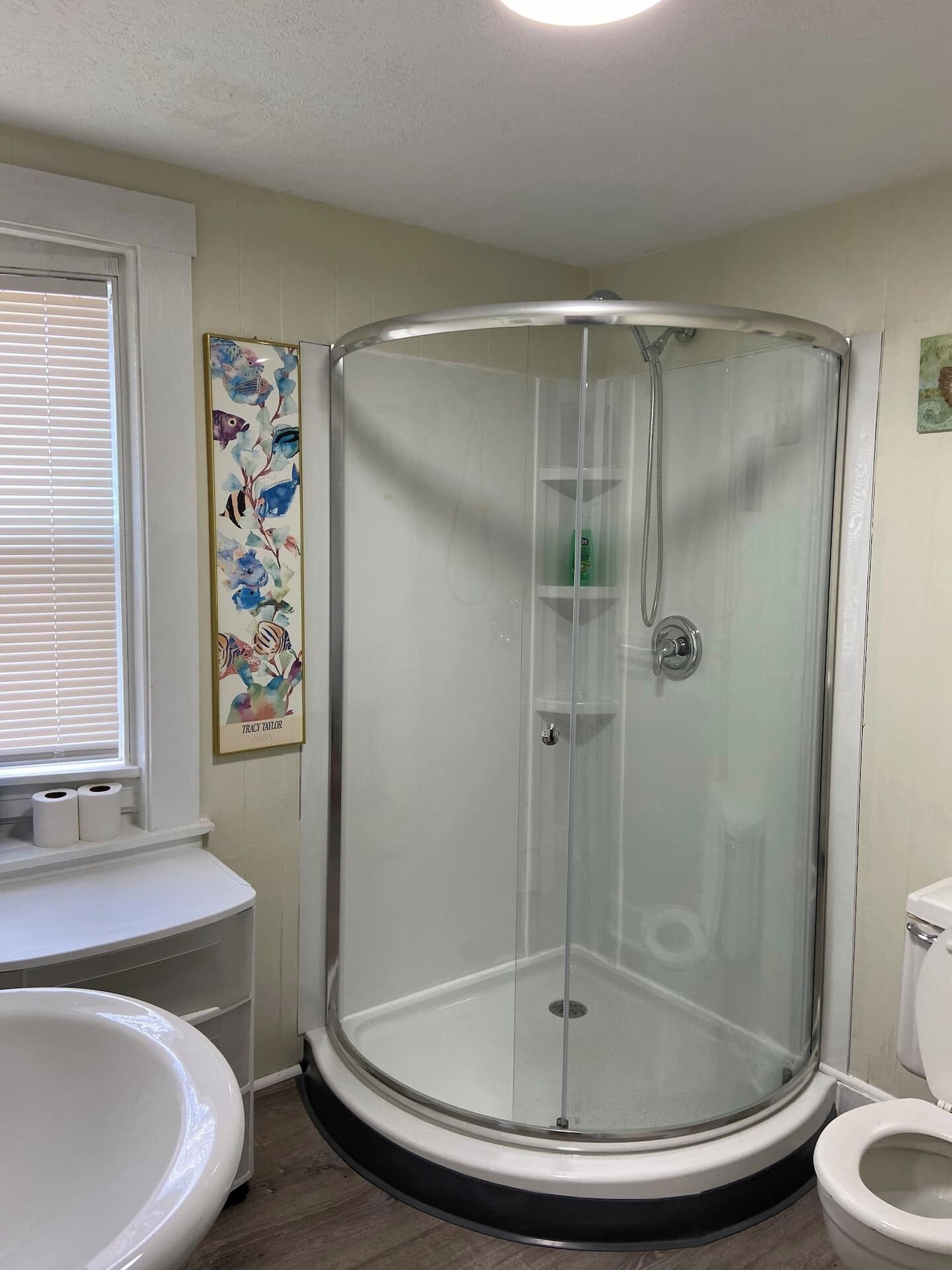 Ein Badezimmer mit Duschkabine, Toilette und Waschbecken.