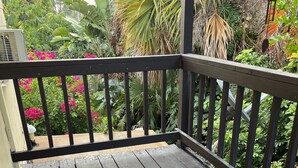 Una terraza de madera con barandilla negra y felpudo.
