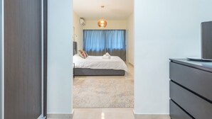 A hotel room with a bed, a TV, a desk, and a bathroom visible through an open door. - KYPSELI PLATINUM (Athens)