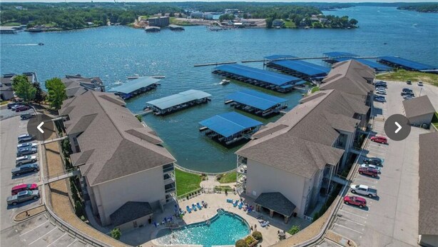A hotel with a swimming pool, docked boats, and a parking lot. - Updated Lands End Upscale Condo - Sleeps 9 (Osage Beach)