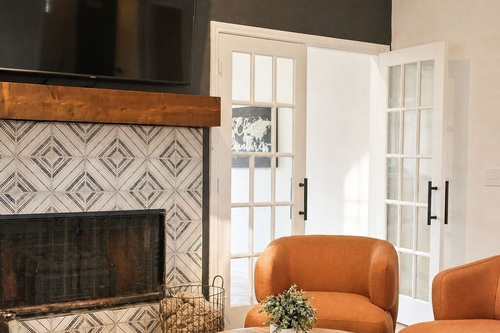 A living room with a fireplace, a sofa, and a door leading outside.