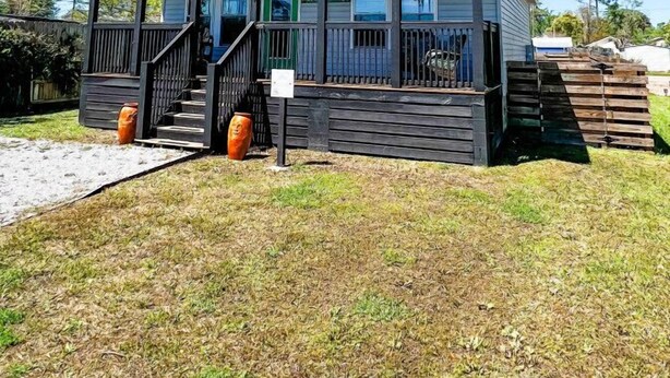 A small, single-story house with a porch, a staircase, and a front door. - Winter Rates at Seize the Bay (Port St. Joe)