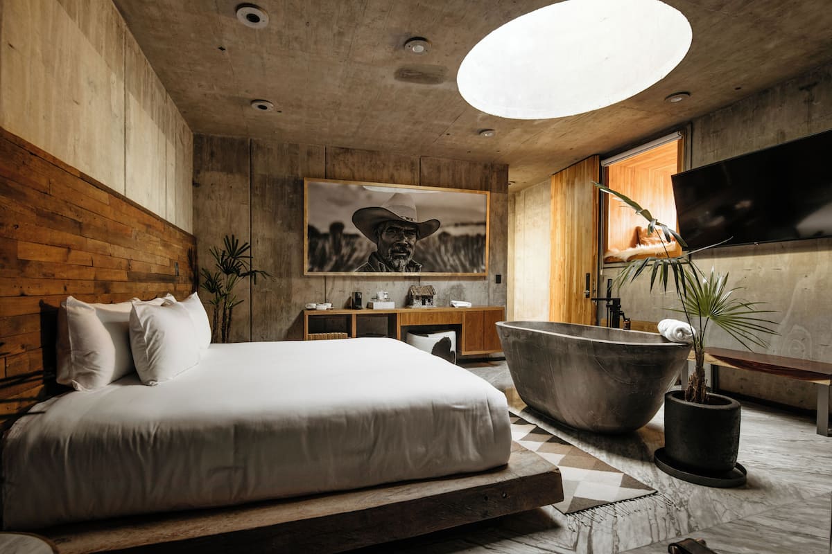 Un dormitorio moderno con una cama grande, una bañera y un televisor.