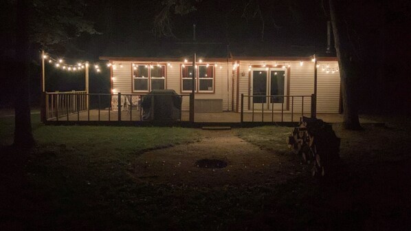 A house with a covered porch, string lights, and a lawn. - Woodland Retreat I Pet Friendly I Mins to Town (Crivitz)