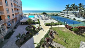 Hotel met zwembad, tennisbaan en uitzicht op het strand.