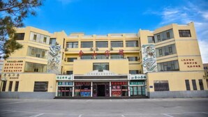 A hotel with a central entrance, multiple floors, and a yellow facade. - Jinshan Hotel (Dunhuang)