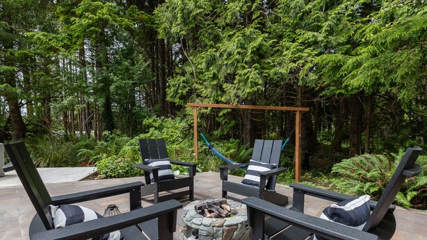 Un espace patio avec des sièges d’extérieur, un foyer et un hamac.