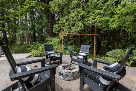 A patio area with outdoor seating, a fire pit, and a hammock.