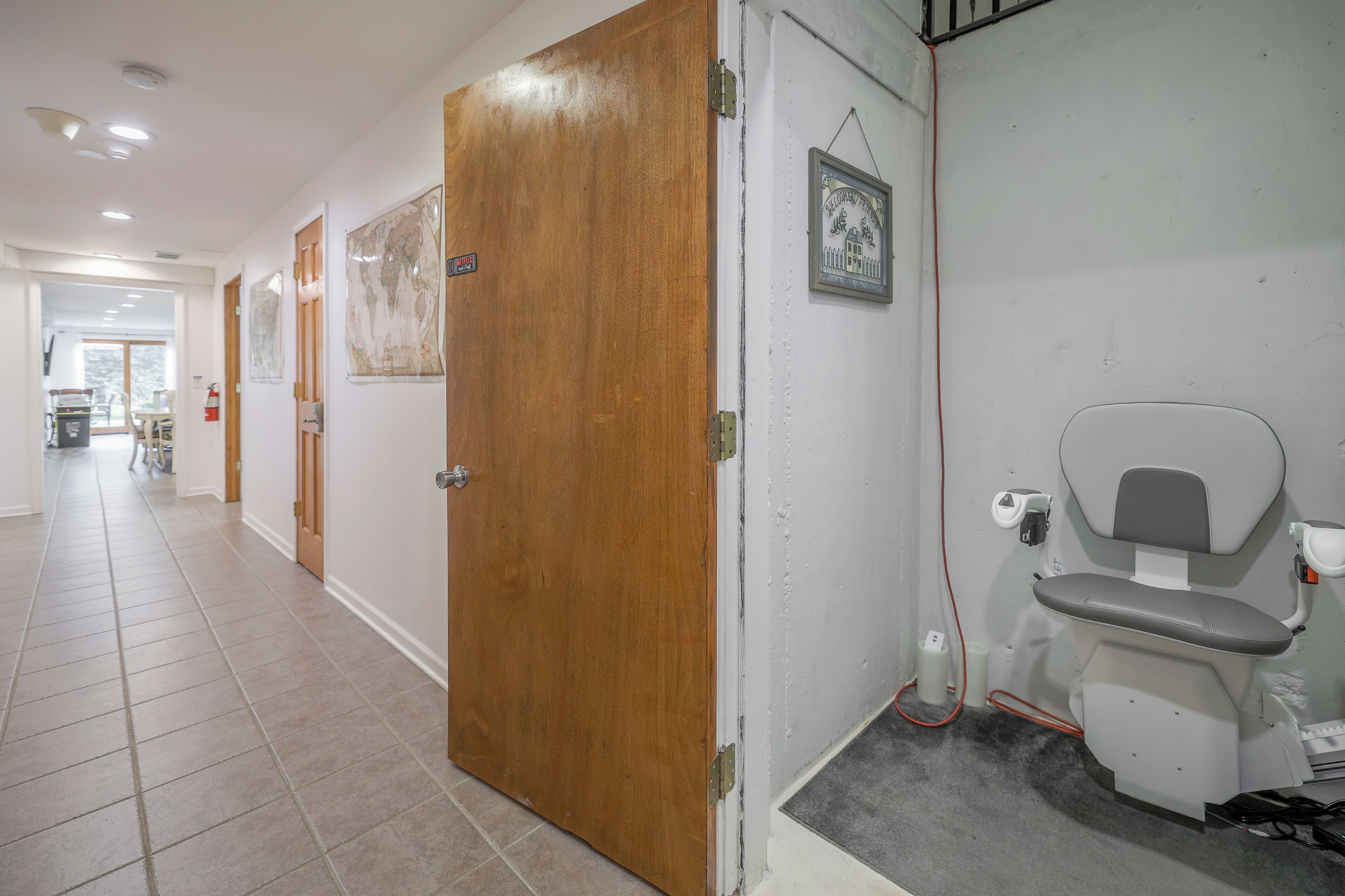 Un pasillo con puertas de madera, un inodoro y un cuadro en la pared.