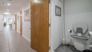 Un pasillo con puertas de madera, un inodoro y un cuadro en la pared.