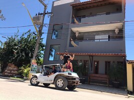 A white off-road vehicle parked in front of a building with a sign reading "Pousada Praia Bonita Milagres, AL".