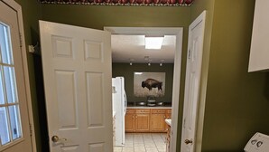 A laundry area with a washing machine, a dryer, and a kitchen in the background. - The Highland Hideaway, perfect for family getaways (Piercetown)