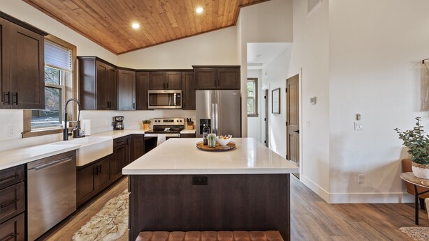 Una cocina moderna con armarios de madera oscura, electrodomésticos de acero inoxidable y una isla grande.
