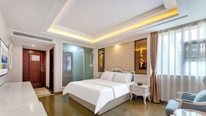 A modern hotel room with a large bed, bedside tables, a desk, and a seating area. - TianQuan Tianyi Jiacheng Hotel (Tianquan)