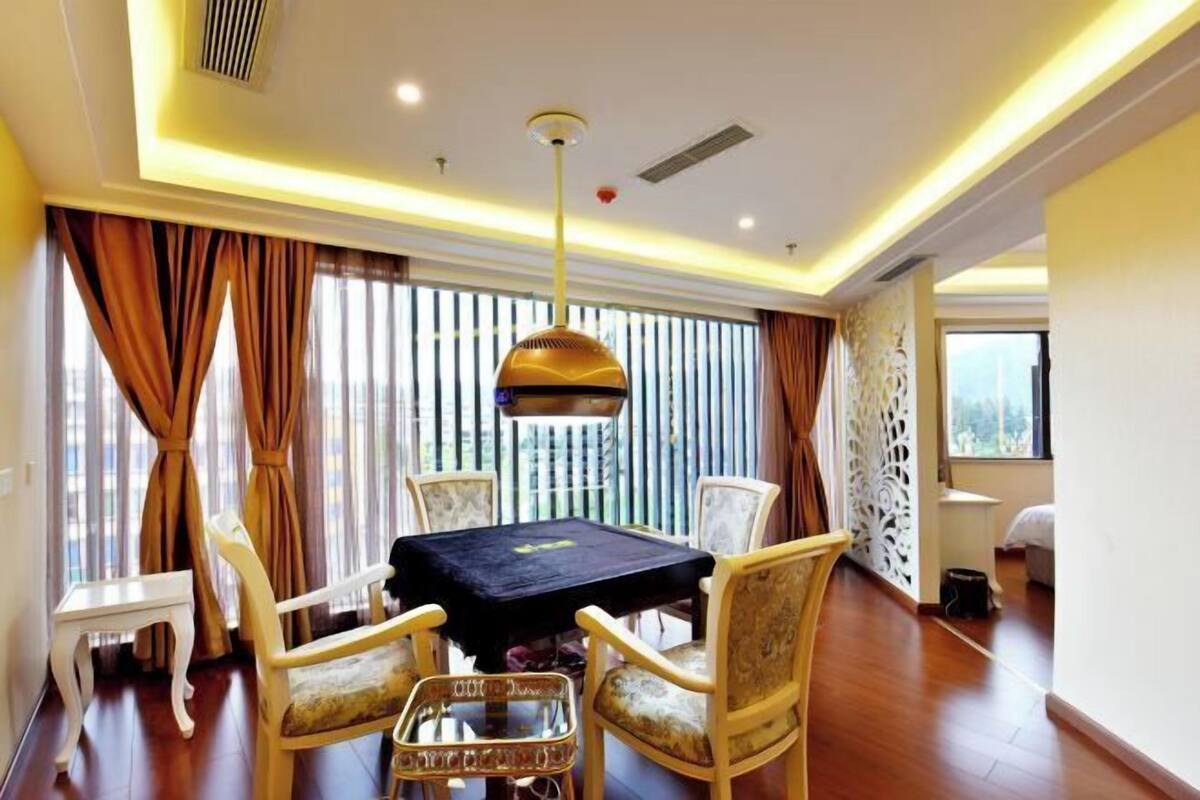 Uma sala de jantar com uma mesa, cadeiras e um lustre.