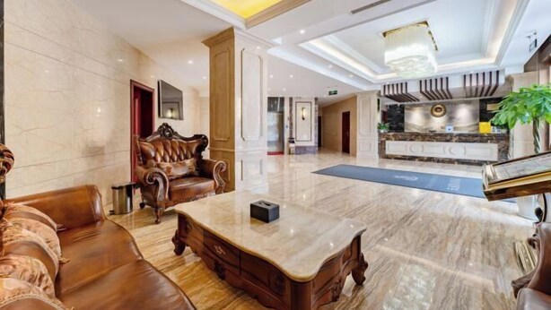 A spacious lobby with a marble floor, leather seating, and a central coffee table. - TianQuan Tianyi Jiacheng Hotel (Tianquan)