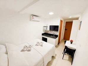 A compact room with a bed, a small kitchenette, a dining area, and a bathroom. - Residencial Engenheiro Paulo Borba (Ipojuca)