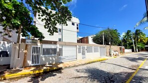A residential building with barred windows, a paved street, and a clear blue sky. - Residencial Engenheiro Paulo Borba (Ipojuca)
