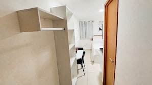 A narrow hallway leading to a bedroom with a bed, a desk, and a chair. - Residencial Engenheiro Paulo Borba (Ipojuca)