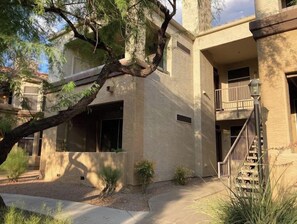 Un edificio con fachada de hormigón, un balcón y una escalera.