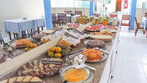 A buffet with various food items and utensils. - Pousada Raio de Sol (Aracaju)