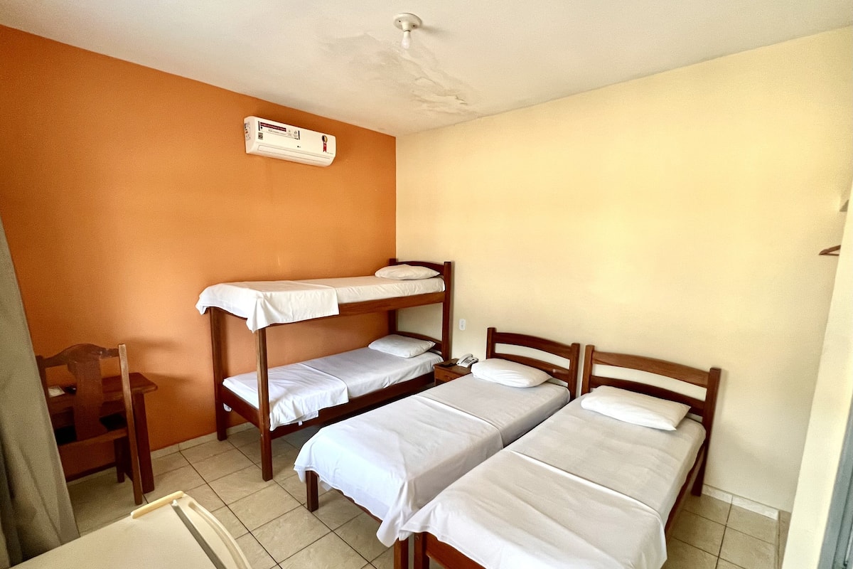 Ein Zimmer mit Etagenbetten, einem Schreibtisch und einem Deckenventilator.