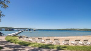 Uma praia com cadeiras de descanso e um píer que se estende para a água.