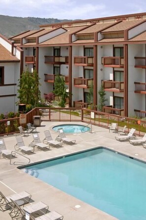 Een verwarmd zwembad, ligstoelen bij het zwembad