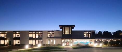 A modern hotel with a flat roof, large windows, and a sign reading "The Watershed."