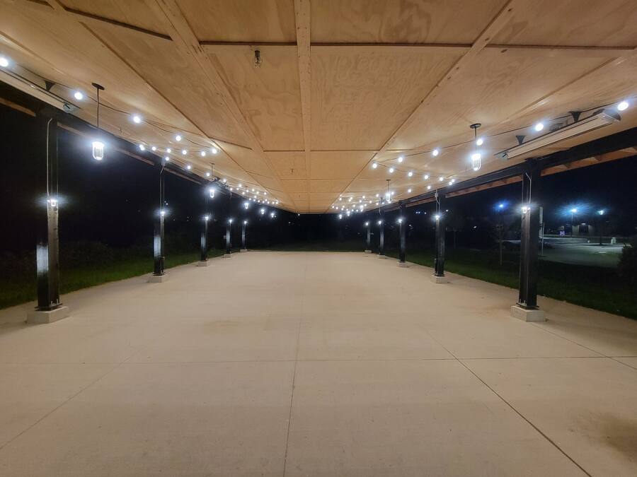Un padiglione all'aperto con soffitto in legno e luci regolarmente distanziate.