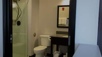A bathroom with a glass-enclosed shower, a white toilet, a black vanity with a mirror, and a white sink.