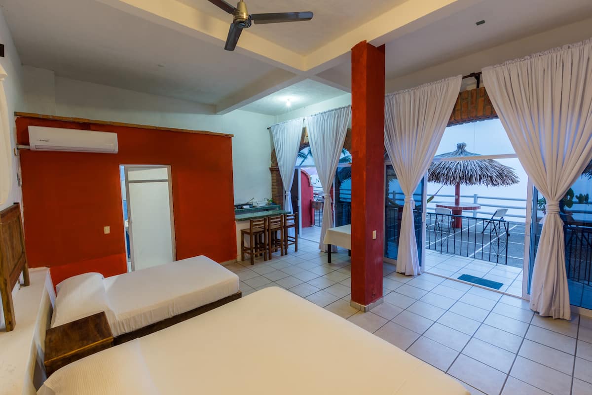 Una habitación de hotel con cama, escritorio y balcón con vistas.