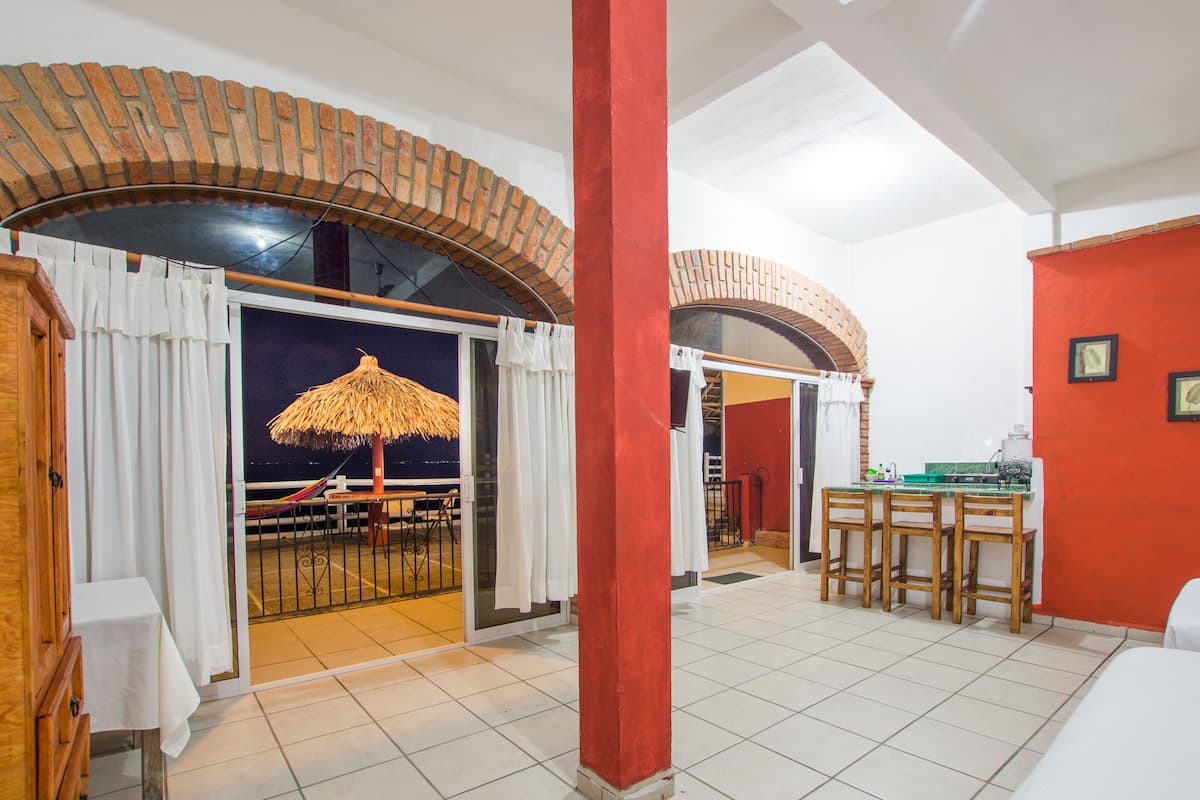 Una habitación amplia con balcón, comedor y cocina.