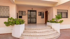 A building entrance with a glass door, numbered 352, and a set of stairs leading up to it. - Quarteira Beach - 2.º D by HelloVacations (Loulé)